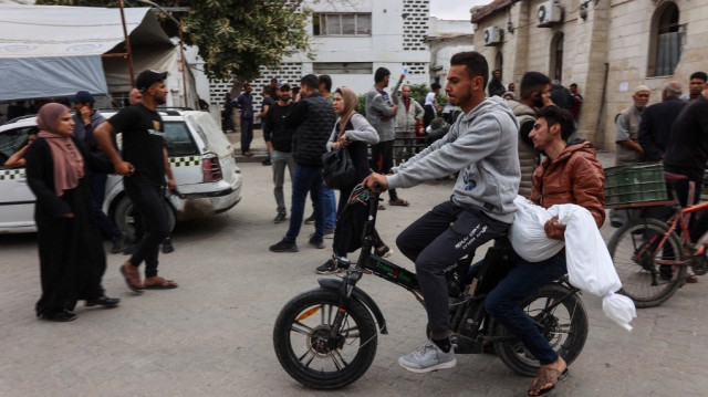 Des Palestiniens à vélo électrique transportent le corps enveloppé d'un enfant avant les funérailles des victimes d'une frappe israélienne sur le quartier de Shujaiyya, à l'hôpital Ahli Arab, également connu sous le nom d'hôpital Maamadani (baptiste), dans la ville de Gaza, le 9 avril 2025.