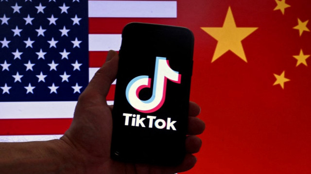 Logo de l'application de médias sociaux TikTok est affiché sur l'écran d'un iPhone, devant un arrière-plan composé des drapeaux américain et chinois, à Washington, le 16 mars 2023.