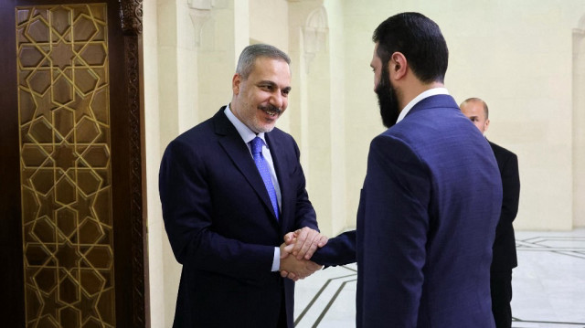 Le ministre turc des Affaires étrangères, Hakan Fidan (G), accueilli par le président intérimaire de la Syrie, Ahmed al-Sharaa, à Damas, le 13 mars 2025.