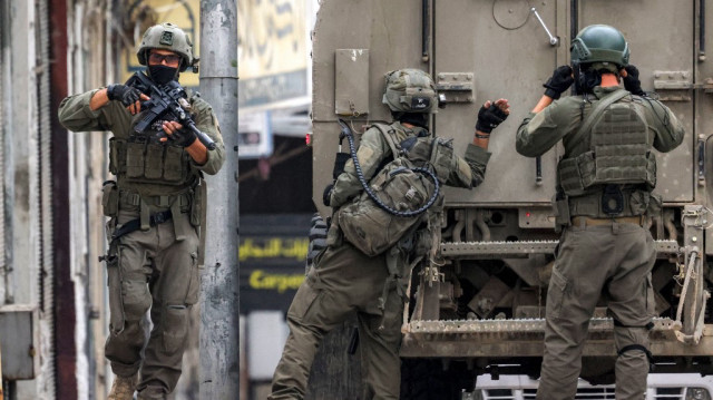 Un soldat de l'armée israélienne frappe à la porte arrière d'un véhicule blindé lors d'une opération militaire à Naplouse, en Palestine occupée, le 8 avril 2025.