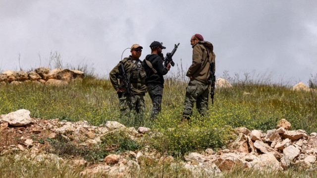 Des soldats israéliens observent depuis une colline après que des bulldozers de l'armée aient démoli des maisons appartenant à la famille Al-Hirsh, dans le village d'Al-Rihaya, au sud de la ville d'Hébron, en Palestine occupée, le 10 avril 2025.