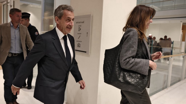 L'ancien président français Nicolas Sarkozy (C) quitte le tribunal avec son épouse Carla Bruni (D) au dernier jour de son procès pour financement illégal de sa campagne par la Libye lors de sa candidature à l'élection présidentielle de 2007, au tribunal de Paris à Paris, le 8 avril 2025.