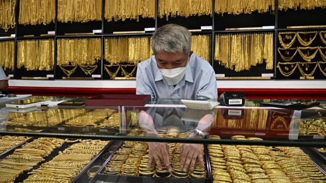 Un employé présente des bijoux en or à des clients chez Hua Seng Heng, un négociant en or situé dans le quartier de Chinatown à Bangkok, le 9 avril 2025.