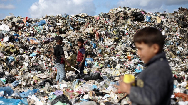 Des enfants palestiniens déplacés fouillent les ordures dans une décharge du camp de réfugiés de Bureij, dans le centre de la bande de Gaza, le 10 avril 2025.