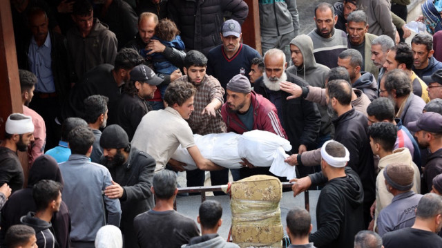 Des Palestiniens transportent le corps d'une personne tuée lors d'une frappe israélienne sur un bâtiment du quartier de Shujaiya, dans la cour de l'hôpital arabe Al-Ahli, dans le nord de la bande de Gaza, le 10 avril 2025.