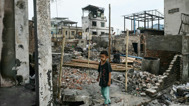 Un garçon se tient parmi les débris des bâtiments endommagés par un incendie à Mandalay, le 11 avril 2025, à la suite du tremblement de terre dévastateur du 28 mars. Le tremblement de terre superficiel de magnitude 7,7 du 28 mars a détruit des bâtiments dans tout le Myanmar, tuant plus de 3 400 personnes et en laissant des milliers d'autres sans abri.
