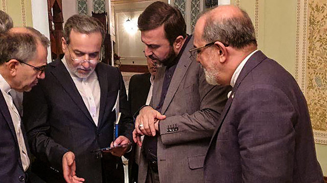 Cette photo fournie par Khabar Online le 12 avril 2025 montre le ministre iranien des Affaires étrangères Abbas Araghchi (2e à gauche) s'entretenant avec des membres de la délégation iranienne après une réunion à Mascate. Les États-Unis veulent un accord nucléaire "dès que possible", a déclaré l'Iran à l'issue de rares discussions le 12 avril, alors que le président américain Donald Trump menace d'une action militaire s'ils ne parviennent pas à un accord. M. Araghchi, qui s'est brièvement entretenu en tête-à-tête avec l'envoyé spécial de M. Trump, Steve Witkoff, lors de la réunion indirecte à Oman, a déclaré que les pourparlers reprendraient le 19 avril.