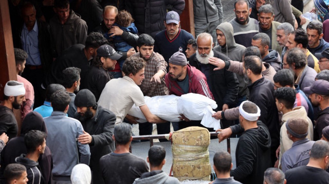 Des Palestiniens transportent le corps d'une personne tuée lors d'une frappe israélienne sur un bâtiment du quartier de Shujaiya, dans la cour de l'hôpital arabe Al-Ahli, dans le nord de la bande de Gaza, le 10 avril 2025.