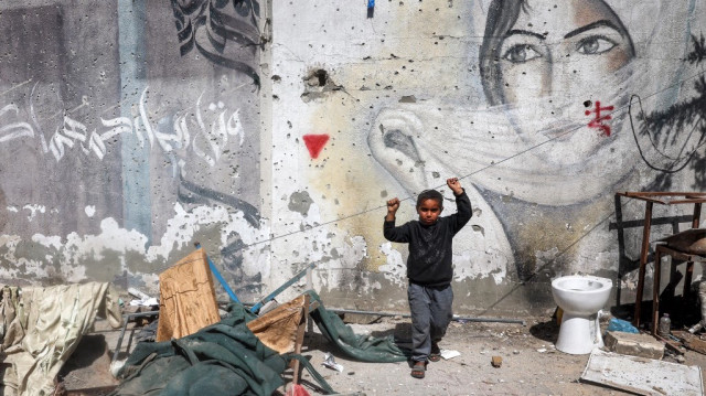 Un garçon se tient à l'emplacement d'une tente touchée par un bombardement israélien à l'école Razi dans le camp de réfugiés palestiniens de Nuseirat, dans le centre de la bande de Gaza, le 24 mars 2025.