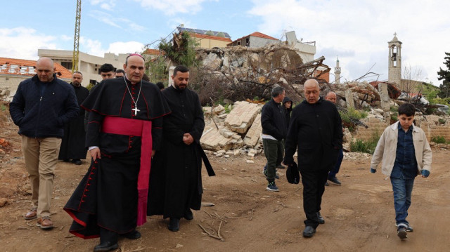 L'envoyé du pape, le prélat italien de l'Eglise catholique Paolo Borgia, se tient avec un prêtre libanais devant un bâtiment détruit par les bombardements israéliens, le dimanche des Rameaux, le 13 avril 2025.