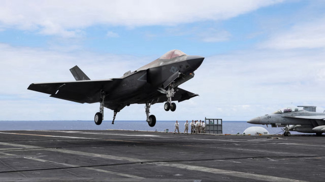 Реактивный самолет F-35 приземляется на взлетно-посадочную полосу авианосца USS Carl Vinson во время военных учений Rim of the Pacific (RIMPAC) в США, 19 июля 2024 года.
