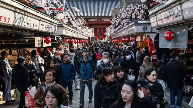 Des personnes marchent le long de la principale rue commerçante du temple Sensoji dans la destination touristique populaire d'Asakusa au centre de Tokyo, le 21 février 2025.