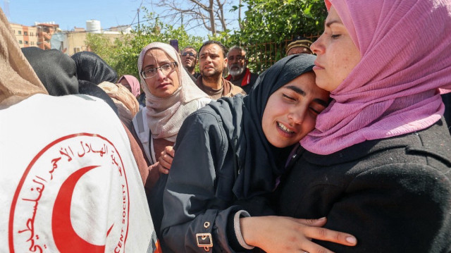 Des proches pleurent lors de la procession funéraire des membres du Croissant-Rouge palestinien et d'autres services d'urgence qui ont été tués une semaine plus tôt par les forces israéliennes, à l'hôpital Nasser de Khan Yunis, dans le sud de la bande de Gaza, le 31 mars 2025.