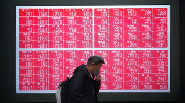 Un homme passe devant un tableau électronique affichant l'indice Nikkei 225 à la bourse de Tokyo, le 10 avril 2025.