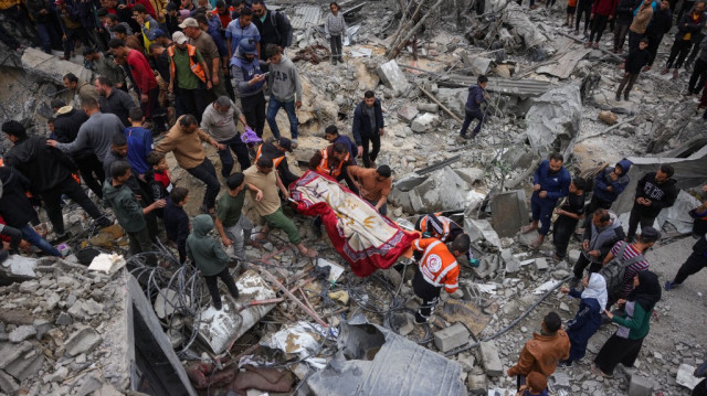 Des sauveteurs palestiniens transportent un corps hors des décombres après une frappe israélienne sur la maison de la famille Manoun à Jabalia, dans le nord de la bande de Gaza, le 13 avril 2025.
