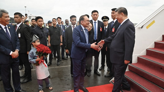 Cette photo prise et diffusée par le ministère malaisien de l'information le 15 avril 2025 montre le Premier ministre malaisien Anwar Ibrahim (C) serrant la main du président chinois Xi Jinping (D) à son arrivée au complexe VIP Bunga Raya de l'aéroport international de Kuala Lumpur à Sepang.