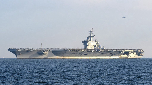 Les membres de l'équipage sont alignés sur le pont alors que le porte-avions à propulsion nucléaire USS George Washington navigue dans la baie de Tokyo vers la base navale américaine de Yokosuka, dans la préfecture de Kanagawa, au sud de Tokyo, le 22 novembre 2024.