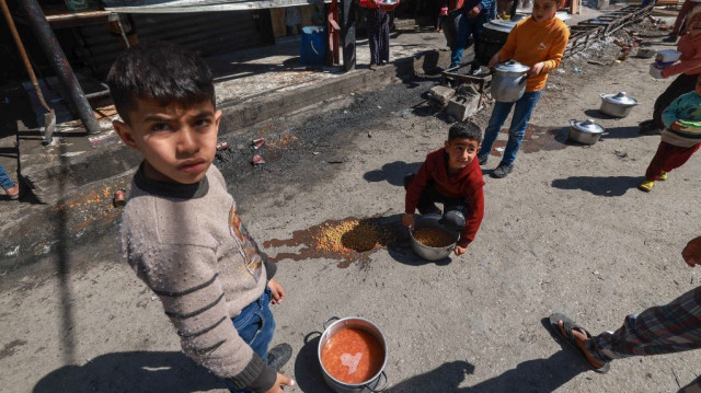 Des enfants palestiniens reçoivent des rations de nourriture cuisinée dans le cadre d'une initiative de jeunes volontaires à Rafah, dans le sud de la bande de Gaza, le 5 mars 2024.