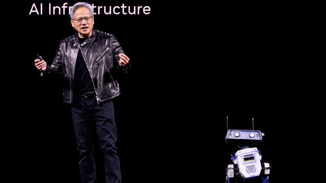Le PDG de Nvidia, Jensen Huang, parle à un robot lors d'une session de présentation au SAP Center de San Jose, en Californie, le 18 mars 2025.