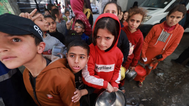 Des enfants palestiniens reçoivent des rations de nourriture cuisinée dans le cadre d'une initiative de jeunes volontaires à Rafah, dans le sud de la bande de Gaza, le 5 mars 2024.