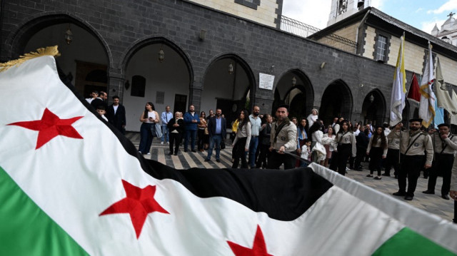 Des scouts brandissent le drapeau national syrien alors qu'ils défilent dans le quartier de Bab Sharqi à Damas, le dimanche des Rameaux, le 13 avril 2025.
