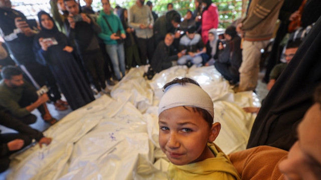 Un garçon légèrement blessé réagit alors que des Palestiniens se recueillent autour des corps de leurs proches tués lors de frappes israéliennes, avant une procession funéraire à l'hôpital Nasser de Khan Yunis, dans le sud de la bande de Gaza, le 2 avril 2025.