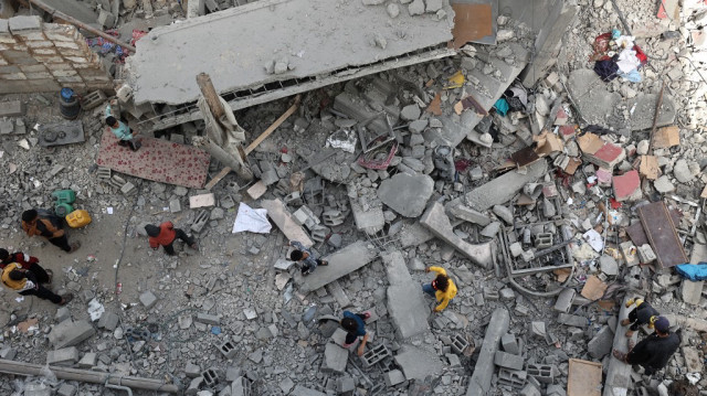 Des enfants palestiniens se tiennent au milieu des décombres d'un bâtiment dans une zone ciblée par des frappes israéliennes à Khan Yunis, dans le sud de la bande de Gaza, le 2 avril 2025.