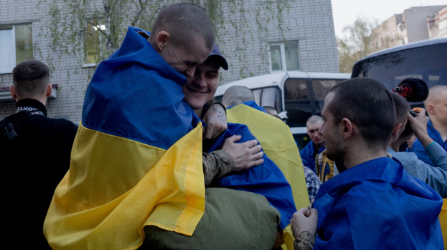 Des prisonniers ukrainiens libérés s'embrassent après avoir été relâchés lors d'un échange de prisonniers dans un lieu tenu secret en Ukraine, le 19 avril 2025, dans le contexte de l'invasion russe de l'Ukraine. Le 19 avril, la Russie et l'Ukraine ont procédé à un vaste échange de prisonniers de guerre, chaque partie déclarant avoir rendu plus de 240 combattants capturés.