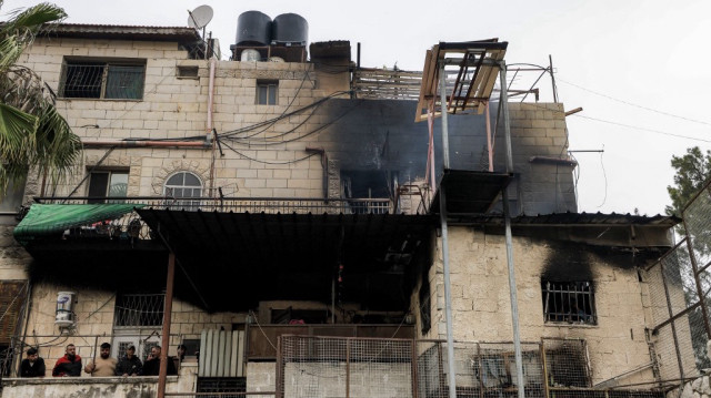 Des hommes se tiennent sur le balcon d'un bâtiment qui a brûlé lors d'une opération militaire israélienne à Naplouse, en Palestine occupée, le 8 avril 2025.