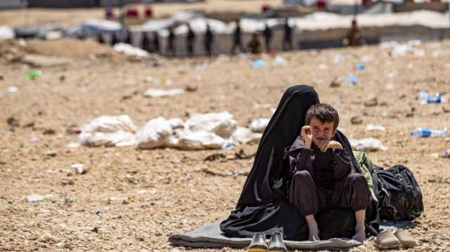 Une femme et un enfant sont assis dans le camp d'al-Hol géré par les Kurdes, qui accueille des proches de combattants présumés du groupe État islamique (EI) dans le gouvernorat de Hasakeh, dans le nord-est du pays, le 18 avril 2025.
