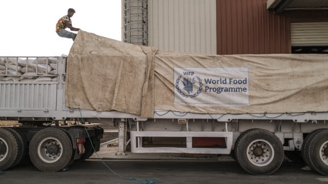 Un ouvrier couvre un camion rempli de sacs de céréales dans un entrepôt du Programme alimentaire mondial (PAM) dans la ville d'Abala, en Éthiopie.