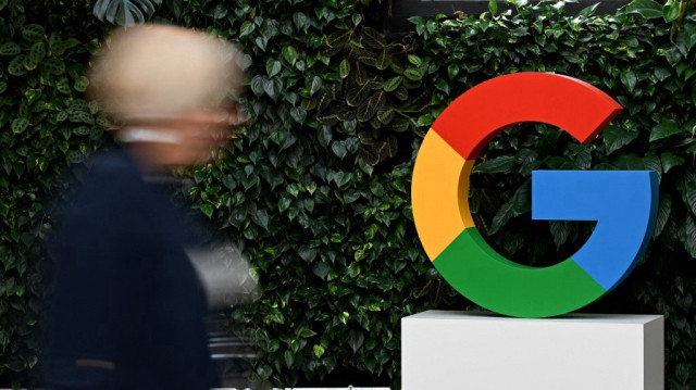 Une femme passe devant un logo de Google sur le campus de Google à Varsovie.