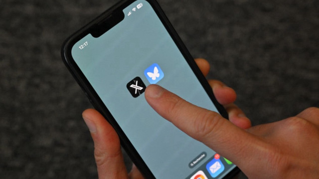 Les logos du réseau social américain X (ex-Twitter) (G) et de Bluesky affichés sur un téléphone portable.
