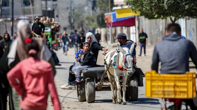 Une femme et des enfants montent à l'arrière d'une charrette tirée par un âne alors que la pénurie de carburant se poursuit à Deir el-Balah, dans le centre de la bande de Gaza, le 24 mars 2025.