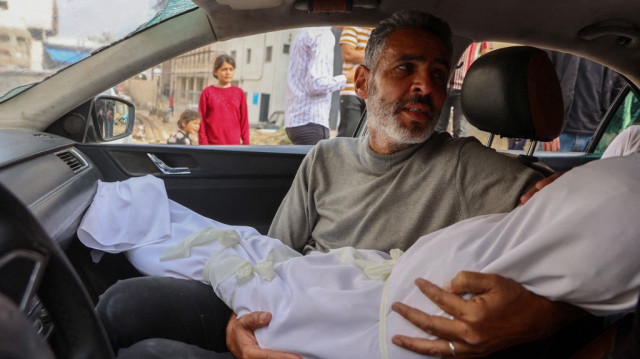Un Palestinien transporte le corps d'un enfant, tué lors d'une frappe israélienne sur une école transformée en refuge, à l'extérieur de l'hôpital Al-Shifa dans la ville de Gaza, le 23 avril 2025.