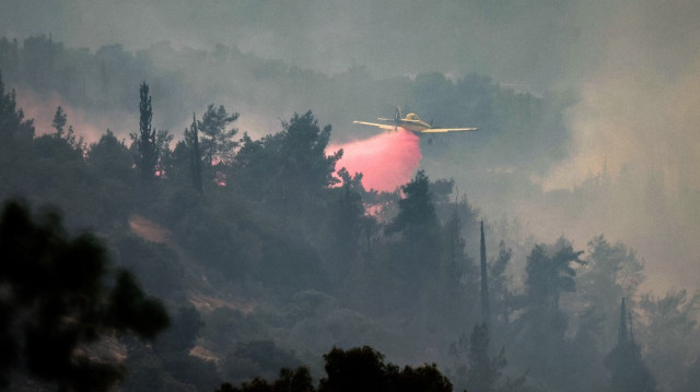 Un avion de lutte contre les incendies Air Tractor AT-802AF largue du retardateur de flamme alors qu'il tente d'éteindre un feu de forêt près de la ville centrale israélienne de Bet Shemesh, près de Jérusalem, le 23 avril 2025.
