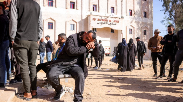 Un homme se repose sur un banc alors que des personnes attendent devant l'hôpital indonésien de Beit Lahia, dans le nord de la bande de Gaza, le 18 avril 2025.