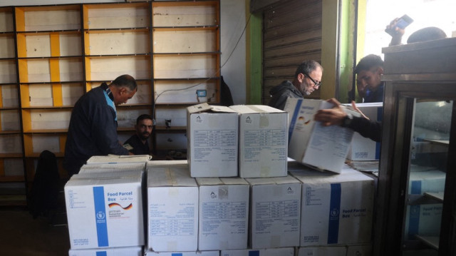 Des personnes font la queue pour recevoir de l'aide humanitaire, fournie par le Programme alimentaire mondial, dans le camp de réfugiés de Bureij, dans le centre de la bande de Gaza, le 18 novembre 2024.