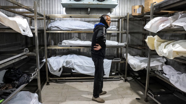 Un homme se tient près des corps des personnes décédées à la morgue du complexe médical Nasser à Khan Yunis dans le sud de la bande de Gaza le 23 décembre 2024.