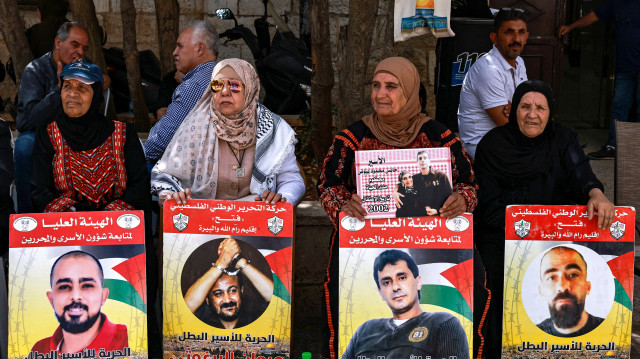 Des manifestants se rassemblent avec des pancartes portant des portraits de Palestiniens actuellement détenus par Israël lors d'une manifestation de solidarité avec eux dans la ville de Ramallah, en Palestine occupée, le 22 avril 2025.