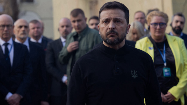 Le président ukrainien Volodymyr Zelensky s'adresse à la presse tandis que des diplomates se tiennent derrière lui près d'un immeuble résidentiel détruit à la suite d'une attaque au missile à Kiev le 25 avril 2025, dans le cadre de l'invasion russe de l'Ukraine.