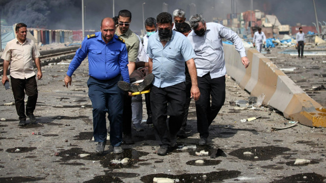 Des personnes transportent un blessé le long d'un boulevard dévasté à la suite d'une explosion au quai du port Shahid Rajaee, au sud-ouest de Bandar Abbas, dans la province iranienne d'Hormozgan, le 26 avril 2025. Plusieurs conteneurs ont explosé le 26 avril dans le plus grand port commercial d'Iran, selon les autorités, provoquant une explosion et un incendie majeurs et faisant des centaines de blessés. Shahid Rajaee, situé à plus de 1 000 kilomètres (620 miles) au sud de la capitale, est le port à conteneurs le plus avancé d'Iran, selon l'agence de presse officielle IRNA.