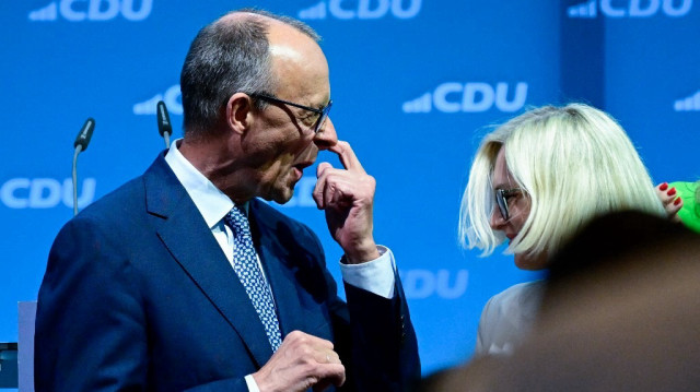 Friedrich Merz (G), chef de file de la CDU, est photographié sur scène à côté de Christiane Schenderlein, désignée ministre des Sports, lors de la réunion du comité fédéral du parti conservateur allemand de l'Union chrétienne-démocrate (CDU), le 28 avril 2025 à Berlin. Le comité a adopté l'accord de coalition négocié avec le parti social-démocrate SPD.