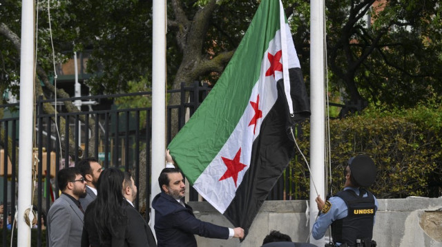 Le ministre syrien des Affaires étrangères, Asaad al-Shaibani, brandit le nouveau drapeau syrien lors d'une cérémonie au siège des Nations Unies à New York, le 25 avril 2025.