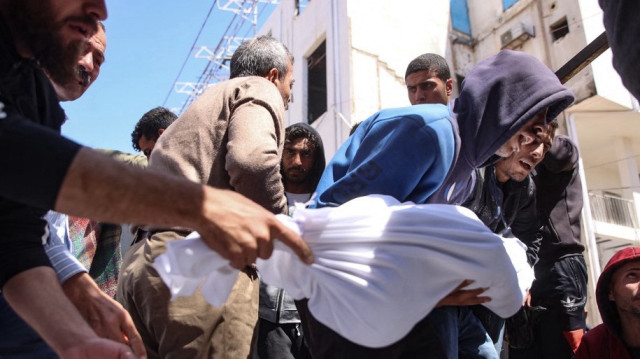 Des personnes portent le corps d'un membre de la famille Al-Khour devant l'hôpital Al-Shifa après que leur maison ait été touchée par une frappe israélienne dans le quartier Sabra de la ville de Gaza, le 26 avril 2025.