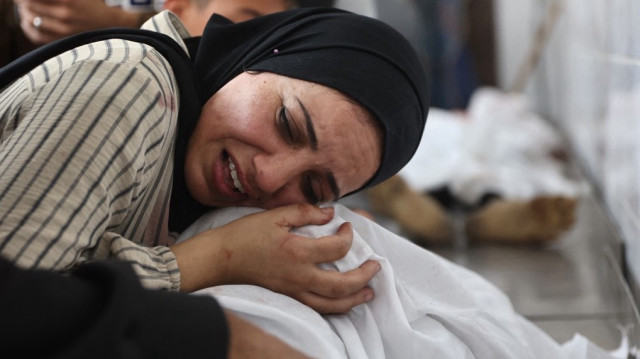 Une femme palestinienne pleure le corps enveloppé d'une personne qui a été tuée lors d'une frappe israélienne dans la rue Al-Jalaa, à l'hôpital Al-Shifa dans la ville de Gaza, dans le centre de la bande de Gaza, le 28 avril 2025.
