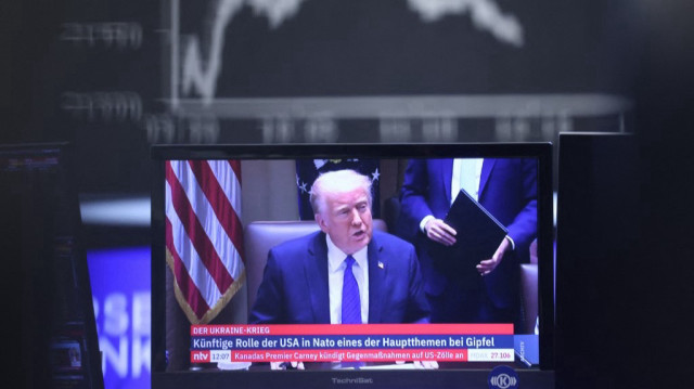 Le président américain Donald Trump est vu sur un écran de télévision en dessous d'un affichage montrant l'indice boursier allemand DAX à la bourse de Francfort, en Allemagne, le 3 avril 2025.