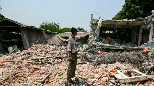 Un homme montre les ruines de l'hôtel où Tin Maung Htwe a été extrait à Sagaing le 3 avril 2025, à la suite du tremblement de terre du 28 mars.