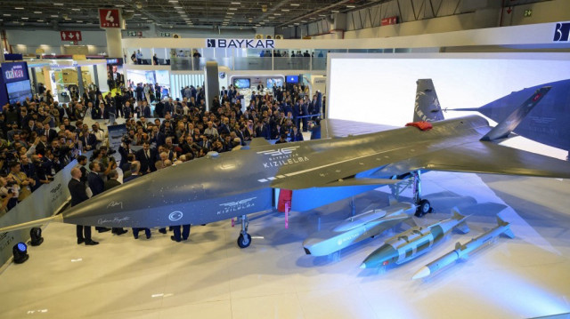 Des visiteurs regardent l'UCAV Bayraktar Kizilelma lors de la journée d'ouverture de la SAHA EXPO 2024, une exposition internationale sur la défense et l'aérospatiale, à Istanbul, le 22 octobre 2024.
