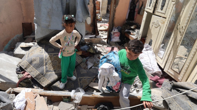 Des enfants palestiniens récupèrent des objets dans les décombres d'une maison détruite par une frappe aérienne israélienne à Khan Yunis, dans le sud de la bande de Gaza, le 31 mars 2025.